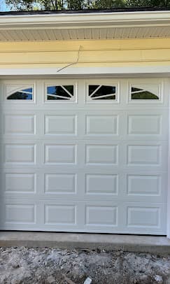 White raised-panel garage door with decorative window inserts